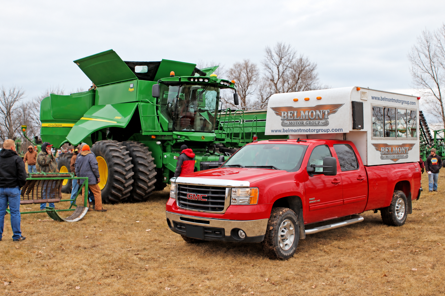 Auction truck beside a green combine